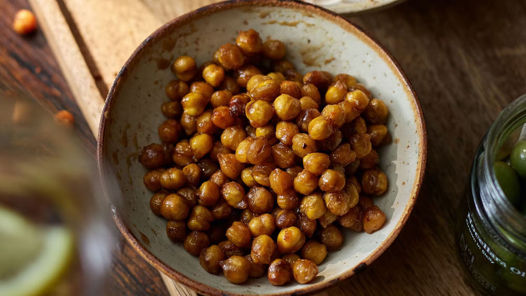Bowl of roasted maple and cinnamon chickpeas on rustic wooden table
