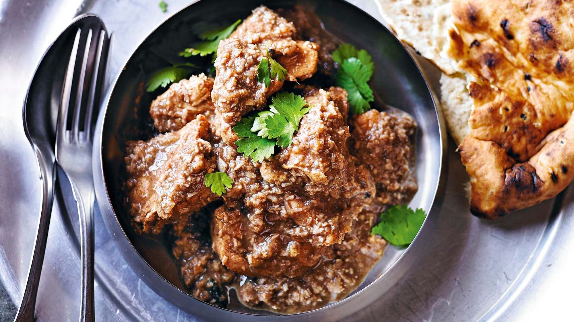 •	Pot of creamy chicken korma simmering with coconut milk and spices.