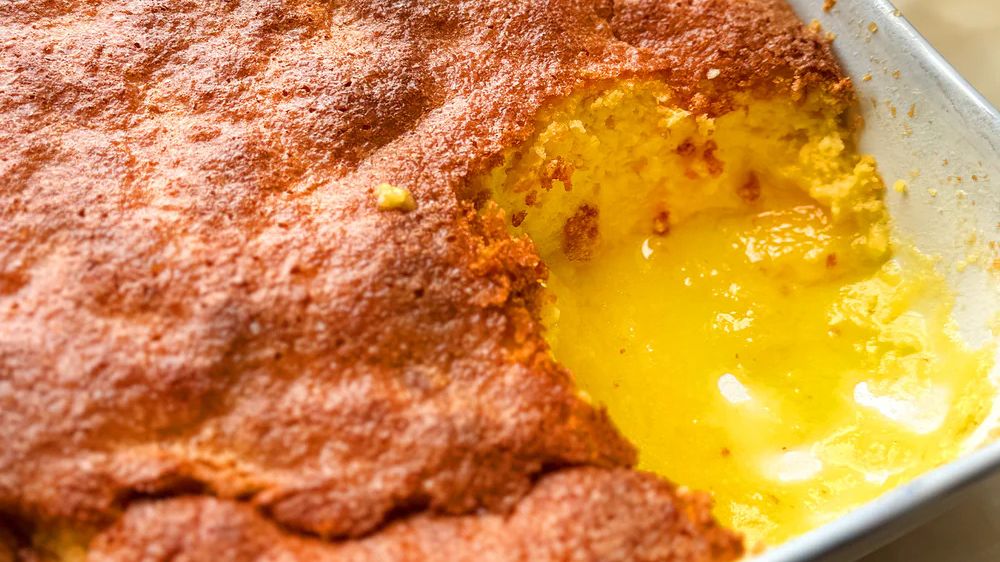 Golden baked lemon pudding with a gooey, creamy lemon center in a baking dish
