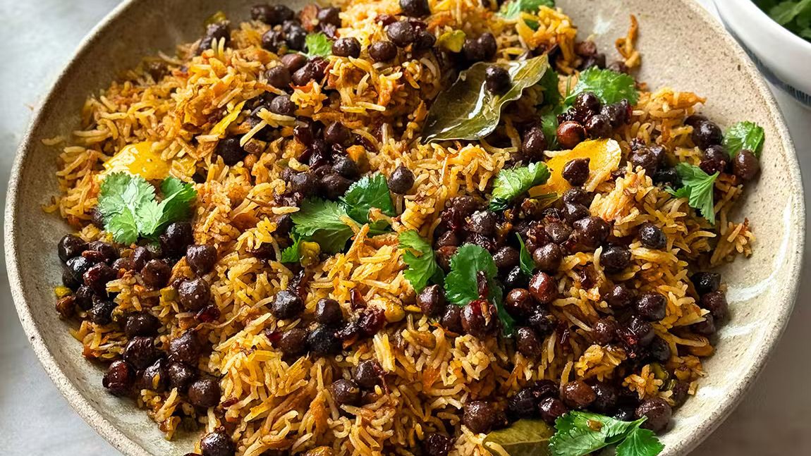 Kabuli pulao rice dish with black chickpeas, spices, and fresh coriander served in a bowl