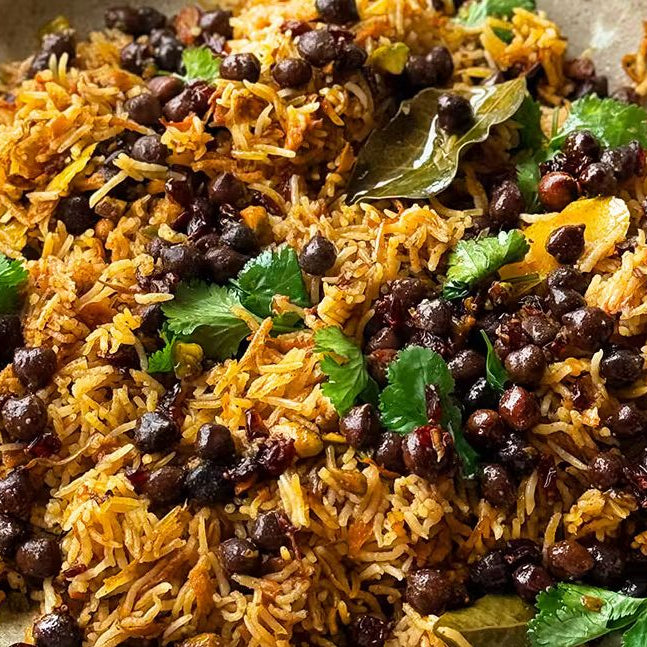 Kabuli pulao rice dish with black chickpeas, spices, and fresh coriander served in a bowl