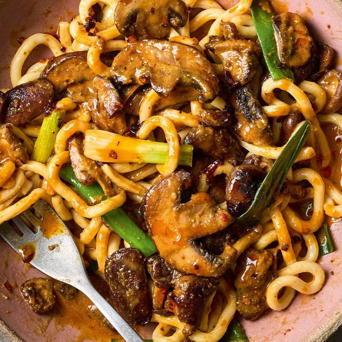Bowl of miso and chilli mushroom noodles with scallions and savory sauce