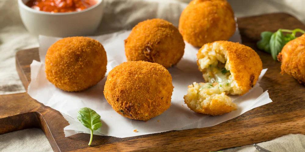 Golden oak-smoked paprika and tomato pesto croquettes on parchment with dipping sauce