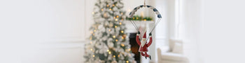 Santa Claus parachute ornament hanging in front of a decorated Christmas tree