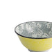 Ceramic bowl with yellow floral pattern outside and black dotted flower design inside